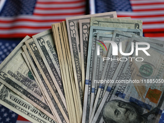 U.S. dollars and a U.S. flag are seen in Shanghai, China, on December 21, 2024. (