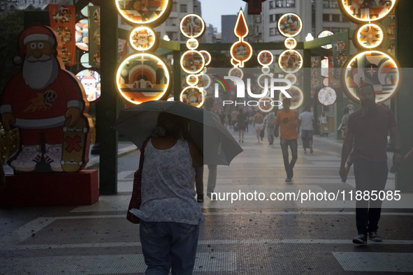 Pedestrians face strong storms in the center of Sao Paulo, Brazil, on December 20, 2024, this Friday afternoon. 