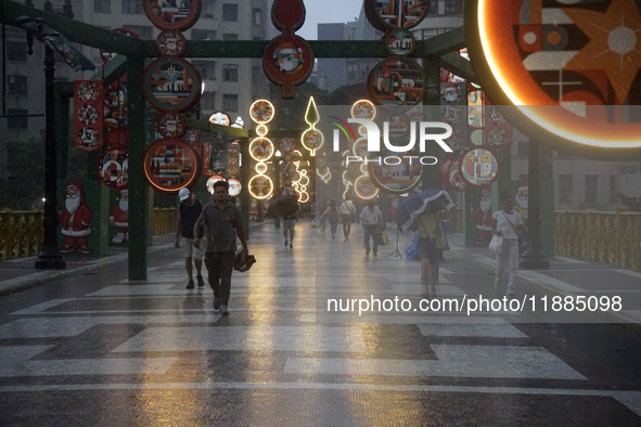 Pedestrians face strong storms in the center of Sao Paulo, Brazil, on December 20, 2024, this Friday afternoon. 