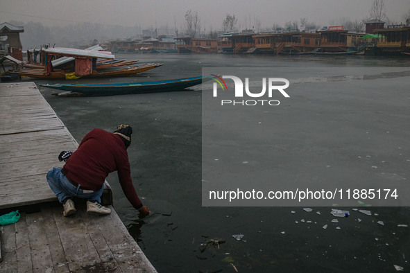 An Indian tourist attempts to break the partially frozen waters of Dal Lake in Srinagar, Jammu and Kashmir, on December 21, 2024. The 40-day...