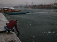 An Indian tourist attempts to break the partially frozen waters of Dal Lake in Srinagar, Jammu and Kashmir, on December 21, 2024. The 40-day...