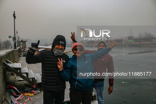 Indian tourists are seen on the banks of Dal Lake in Srinagar, Jammu and Kashmir, on December 21, 2024. The 40-day harsh winter period, loca...