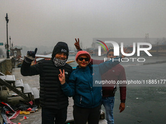 Indian tourists are seen on the banks of Dal Lake in Srinagar, Jammu and Kashmir, on December 21, 2024. The 40-day harsh winter period, loca...