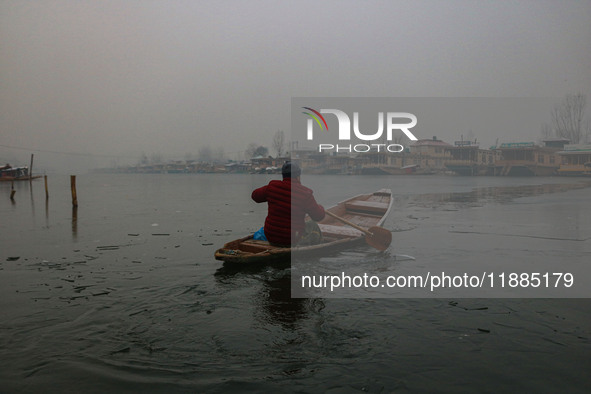 A boatman rows his boat on partially frozen waters at Dal Lake in Srinagar, Jammu and Kashmir, on December 21, 2024. The 40-day harsh winter...