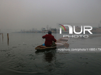 A boatman rows his boat on partially frozen waters at Dal Lake in Srinagar, Jammu and Kashmir, on December 21, 2024. The 40-day harsh winter...