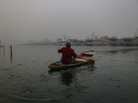 A boatman rows his boat on partially frozen waters at Dal Lake in Srinagar, Jammu and Kashmir, on December 21, 2024. The 40-day harsh winter...