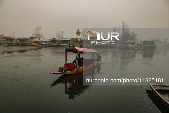 A boatman rows his boat on partially frozen waters at Dal Lake in Srinagar, Jammu and Kashmir, on December 21, 2024. The 40-day harsh winter...