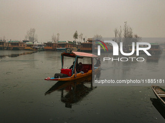 A boatman rows his boat on partially frozen waters at Dal Lake in Srinagar, Jammu and Kashmir, on December 21, 2024. The 40-day harsh winter...