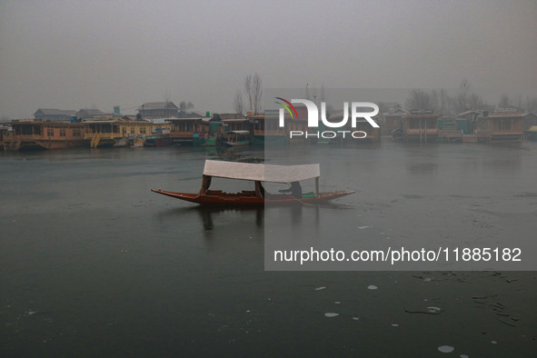 A boatman rows his boat on partially frozen waters at Dal Lake in Srinagar, Jammu and Kashmir, on December 21, 2024. The 40-day harsh winter...