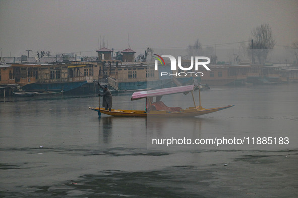 A boatman rows his boat on partially frozen waters at Dal Lake in Srinagar, Jammu and Kashmir, on December 21, 2024. The 40-day harsh winter...