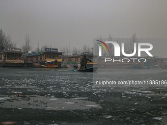 A boatman rows his boat on partially frozen waters at Dal Lake in Srinagar, Jammu and Kashmir, on December 21, 2024. The 40-day harsh winter...