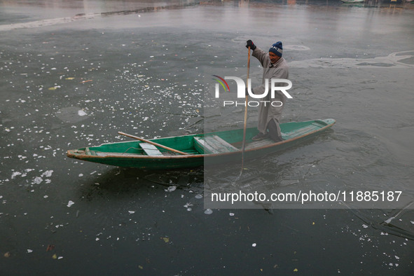 A boatman rows his boat on partially frozen waters at Dal Lake in Srinagar, Jammu and Kashmir, on December 21, 2024. The 40-day harsh winter...