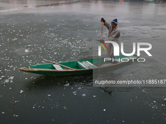 A boatman rows his boat on partially frozen waters at Dal Lake in Srinagar, Jammu and Kashmir, on December 21, 2024. The 40-day harsh winter...