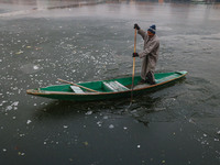 A boatman rows his boat on partially frozen waters at Dal Lake in Srinagar, Jammu and Kashmir, on December 21, 2024. The 40-day harsh winter...