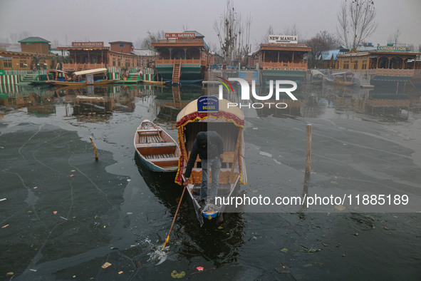 A boatman rows his boat on partially frozen waters at Dal Lake in Srinagar, Jammu and Kashmir, on December 21, 2024. The 40-day harsh winter...