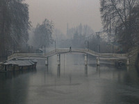 A man walks over a wooden bridge in Srinagar, Jammu and Kashmir, on December 21, 2024. The 40-day harsh winter period, locally referred to a...