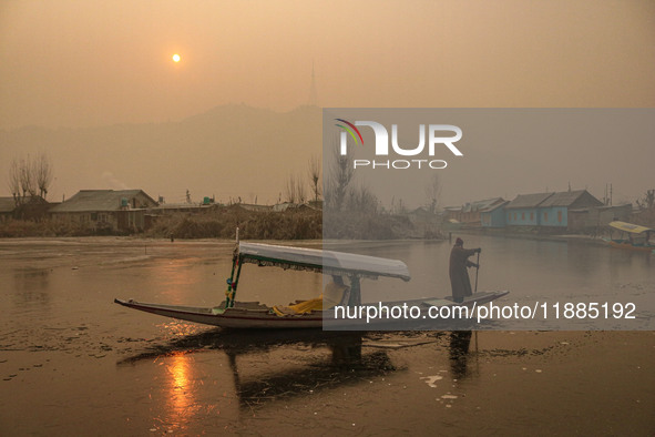 A boatman rows his boat on partially frozen waters at Dal Lake in Srinagar, Jammu and Kashmir, on December 21, 2024. The 40-day harsh winter...