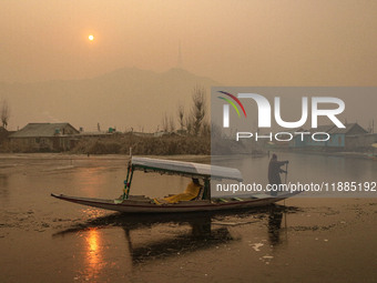 A boatman rows his boat on partially frozen waters at Dal Lake in Srinagar, Jammu and Kashmir, on December 21, 2024. The 40-day harsh winter...