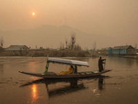 A boatman rows his boat on partially frozen waters at Dal Lake in Srinagar, Jammu and Kashmir, on December 21, 2024. The 40-day harsh winter...