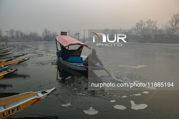 A man uses an oar to break the partially frozen waters of Dal Lake in Srinagar, Jammu and Kashmir, on December 21, 2024. The 40-day harsh wi...