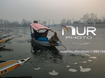 A man uses an oar to break the partially frozen waters of Dal Lake in Srinagar, Jammu and Kashmir, on December 21, 2024. The 40-day harsh wi...