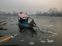 A man uses an oar to break the partially frozen waters of Dal Lake in Srinagar, Jammu and Kashmir, on December 21, 2024. The 40-day harsh wi...