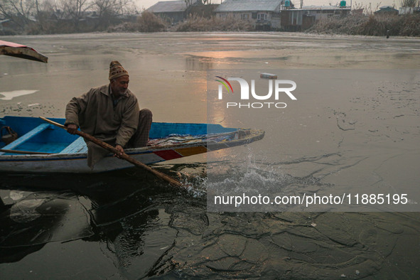 A man uses an oar to break the partially frozen waters of Dal Lake in Srinagar, Jammu and Kashmir, on December 21, 2024. The 40-day harsh wi...