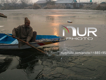 A man uses an oar to break the partially frozen waters of Dal Lake in Srinagar, Jammu and Kashmir, on December 21, 2024. The 40-day harsh wi...