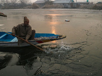 A man uses an oar to break the partially frozen waters of Dal Lake in Srinagar, Jammu and Kashmir, on December 21, 2024. The 40-day harsh wi...