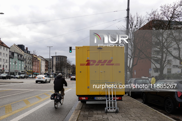 A DHL delivery vehicle parks in a residential area in Munich, Bavaria, Germany, on December 20, 2024 