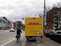 A DHL delivery vehicle parks in a residential area in Munich, Bavaria, Germany, on December 20, 2024 (