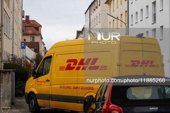 A DHL delivery vehicle parks in a residential area in Munich, Bavaria, Germany, on December 20, 2024 