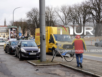 A DHL delivery vehicle parks in a residential area in Munich, Bavaria, Germany, on December 20, 2024 (