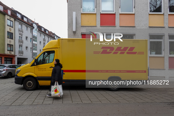 A DHL delivery vehicle parks in a residential area in Munich, Bavaria, Germany, on December 20, 2024 