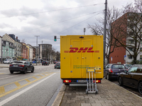 A DHL delivery vehicle parks in a residential area in Munich, Bavaria, Germany, on December 20, 2024 (