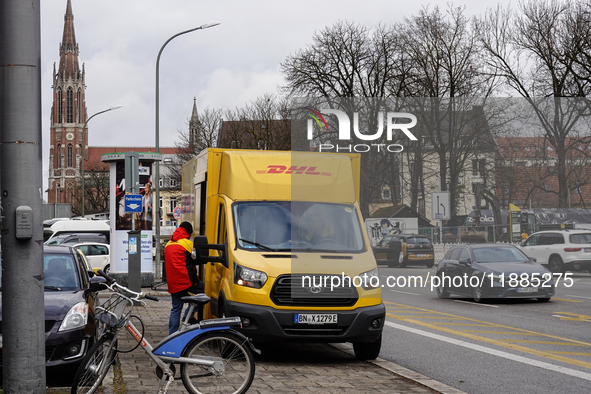 A DHL delivery vehicle parks in a residential area in Munich, Bavaria, Germany, on December 20, 2024 