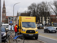 A DHL delivery vehicle parks in a residential area in Munich, Bavaria, Germany, on December 20, 2024 (