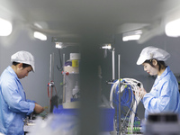 Workers produce photoelectric cables for export at a workshop of a company that produces communication equipment in the Sihong Economic Deve...