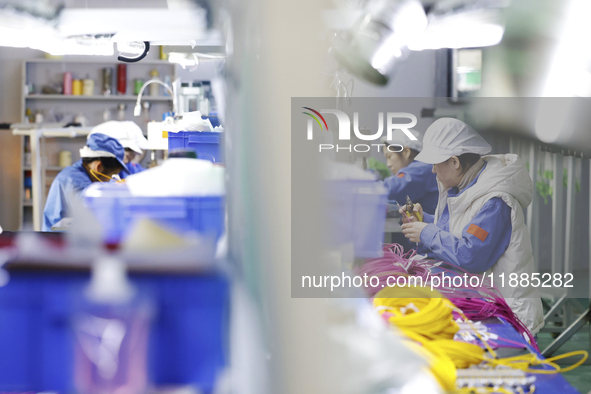 Workers produce photoelectric cables for export at a workshop of a company that produces communication equipment in the Sihong Economic Deve...