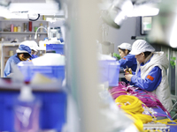 Workers produce photoelectric cables for export at a workshop of a company that produces communication equipment in the Sihong Economic Deve...