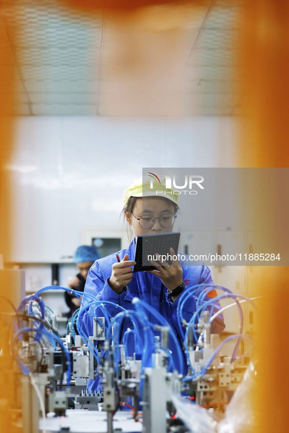 A worker produces photoelectric cables for export at a workshop of a communication equipment company in the Sihong Economic Development Zone...