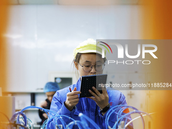 A worker produces photoelectric cables for export at a workshop of a communication equipment company in the Sihong Economic Development Zone...