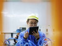 A worker produces photoelectric cables for export at a workshop of a communication equipment company in the Sihong Economic Development Zone...