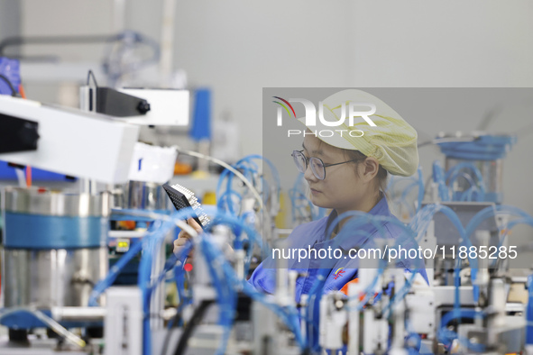 A worker produces photoelectric cables for export at a workshop of a communication equipment company in the Sihong Economic Development Zone...