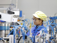 A worker produces photoelectric cables for export at a workshop of a communication equipment company in the Sihong Economic Development Zone...