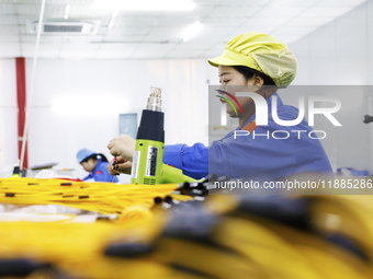 A worker produces photoelectric cables for export at a workshop of a communication equipment company in the Sihong Economic Development Zone...