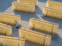 A worker places hanging noodles on a shelf to dry in Hefei, Anhui province, China, on December 21, 2024. (