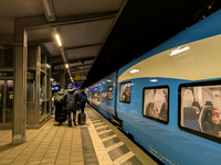 A regional train and passengers with luggage are on a platform at Munich Pasing station in Munich, Bavaria, Germany, on December 20, 2024. (