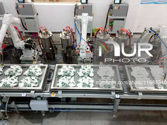 An employee operates an AI intelligent dyeing robot to produce intangible cultural heritage tie-dyeing products in a workshop in Hai'an, Jia...