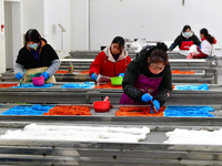 An employee operates an AI intelligent dyeing robot to produce intangible cultural heritage tie-dyeing products in a workshop in Hai'an, Jia...